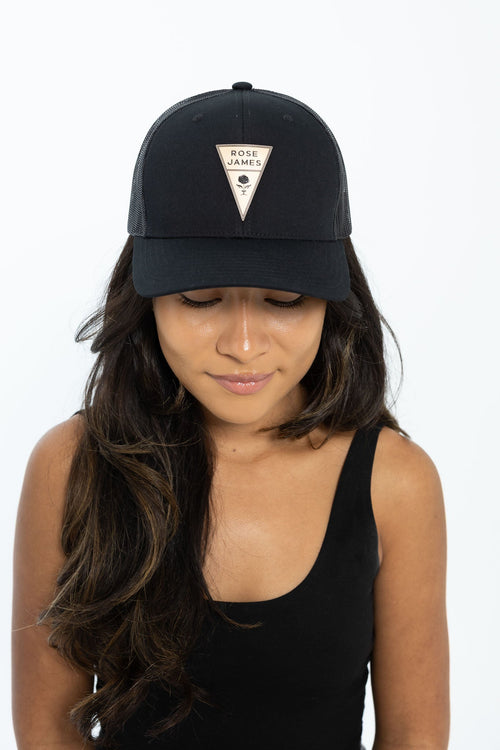 Person wearing a black cap with a logo on a white background