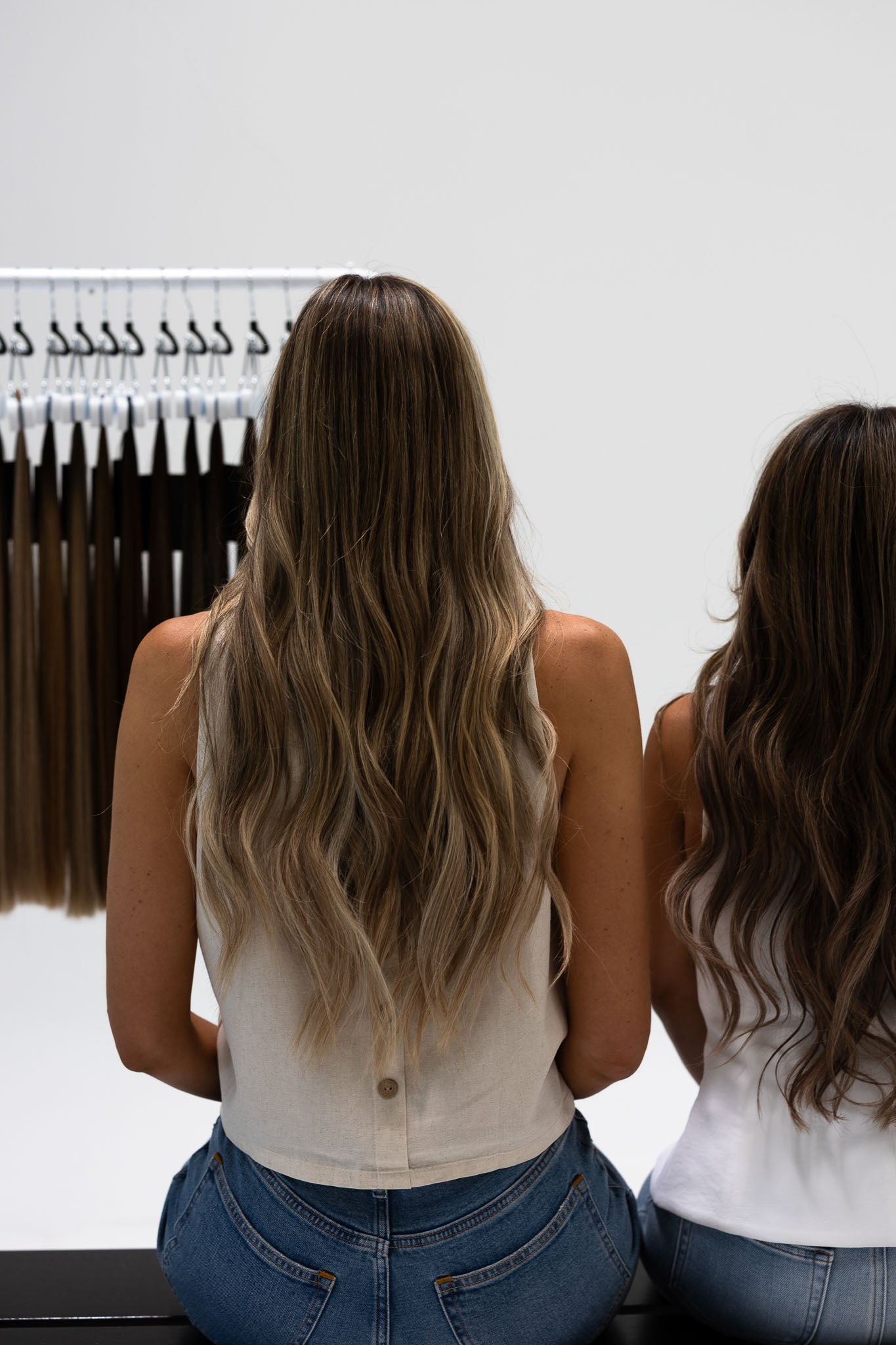 Two women looking at a rack of hair extensions in North Phoenix salon.