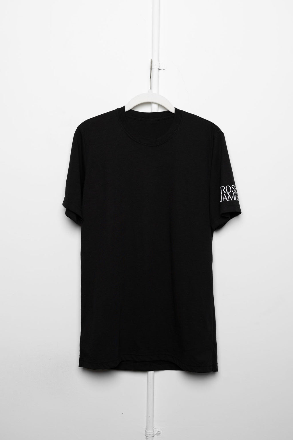Black t-shirt with text on sleeve hanging against a white background