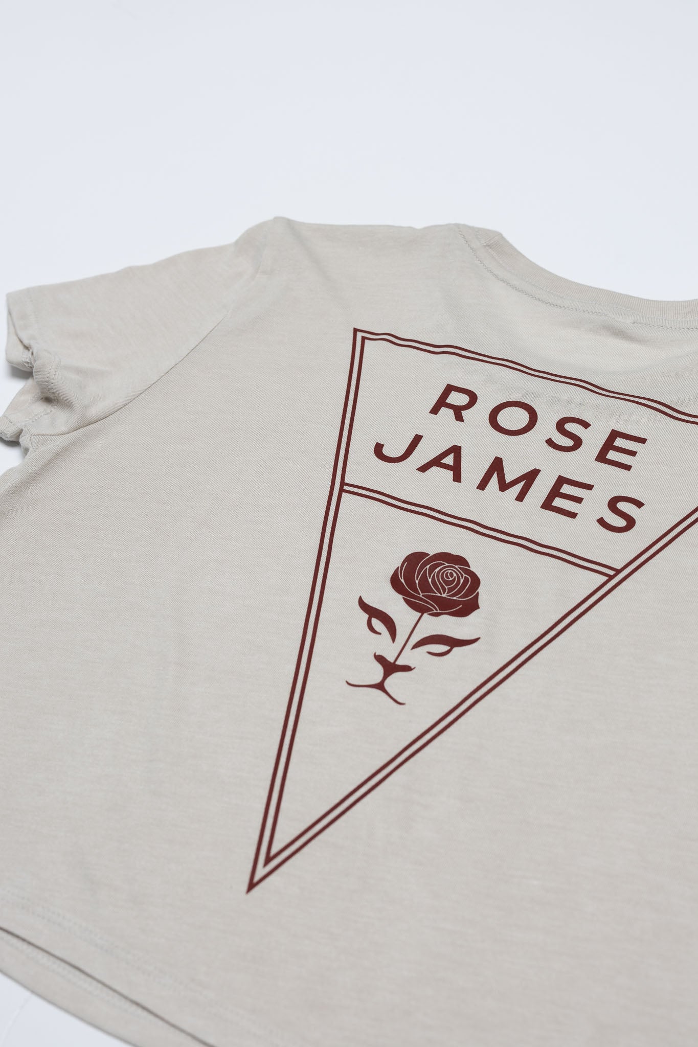 Beige t-shirt with 'Rose James' logo on a white background