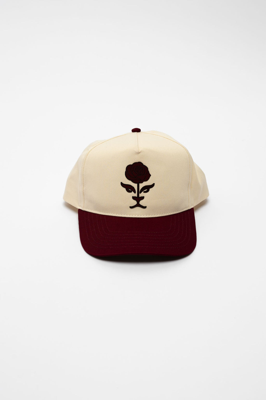 Beige and maroon cap with a black logo on a white background
