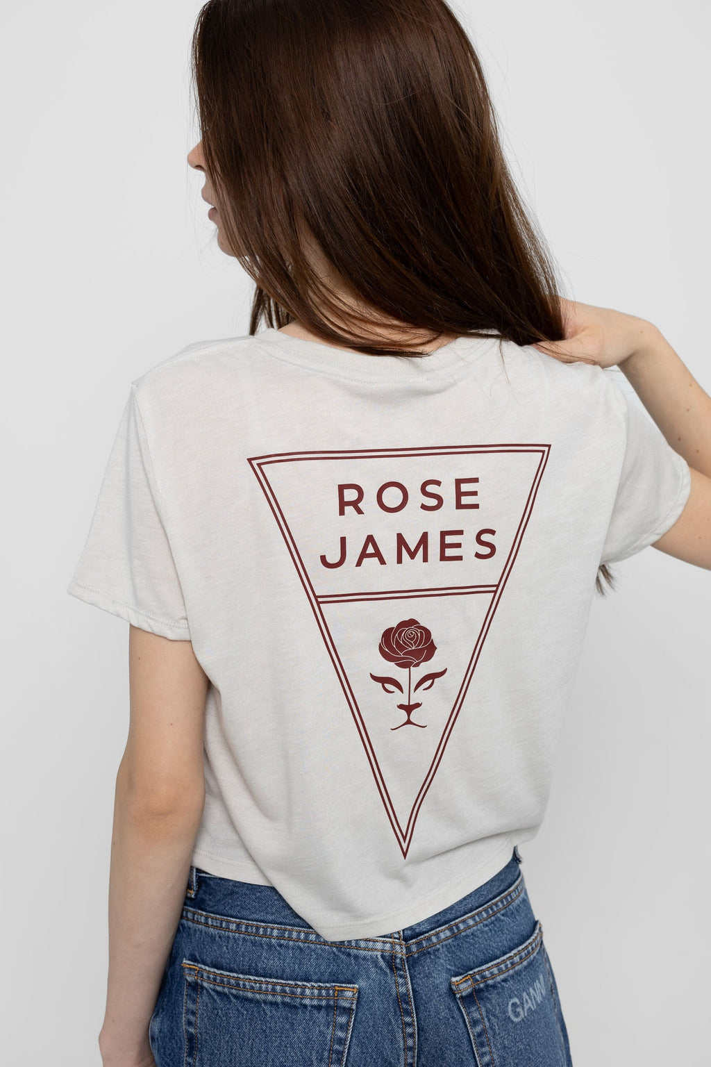 Person wearing a cream t-shirt with 'Rose James' design on the back against a plain background