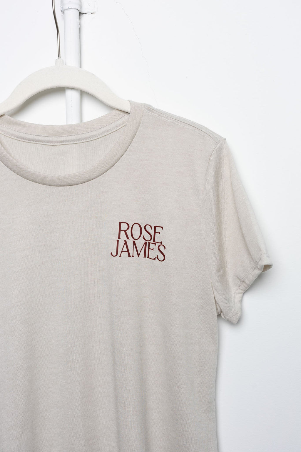 Beige t-shirt with 'ROSE JAMES' text on a white background