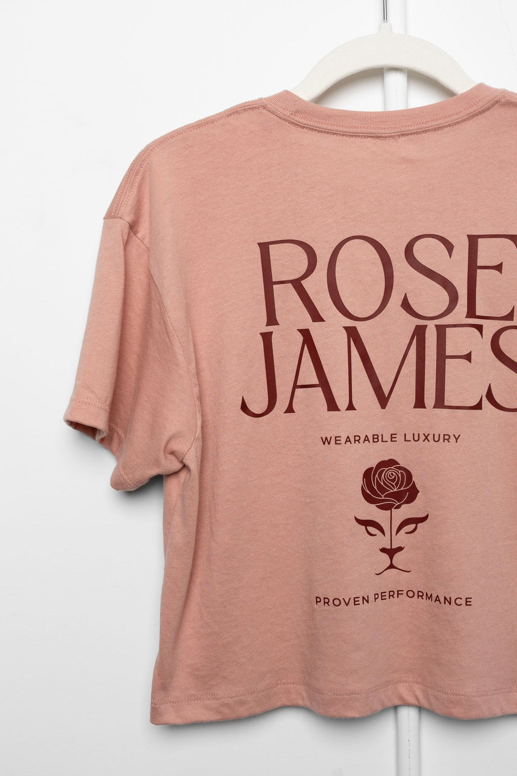 Pink t-shirt with 'Rose James' branding on a white hanger