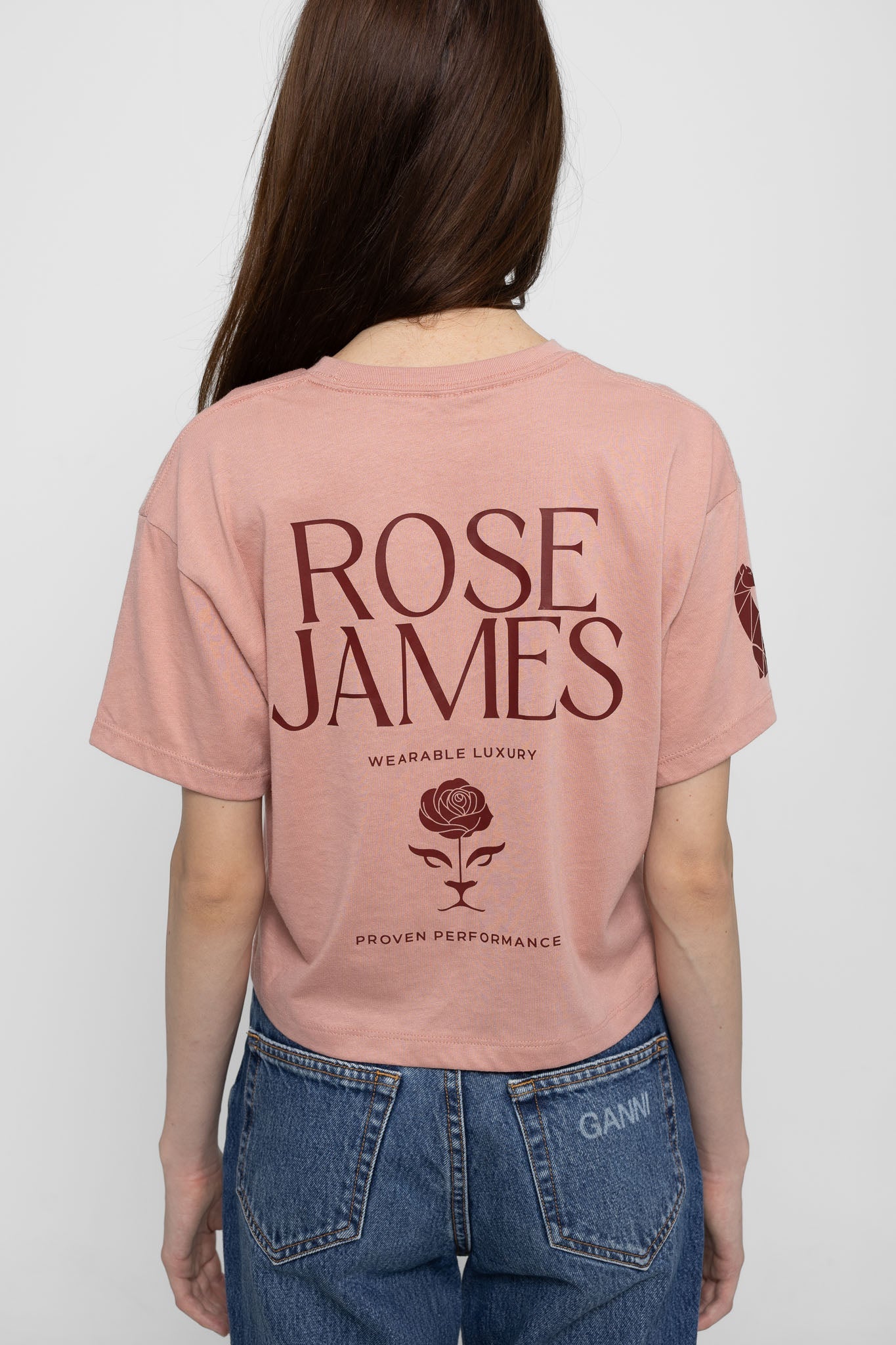 Person wearing a pink 'Rose James' t-shirt with branding on the back.