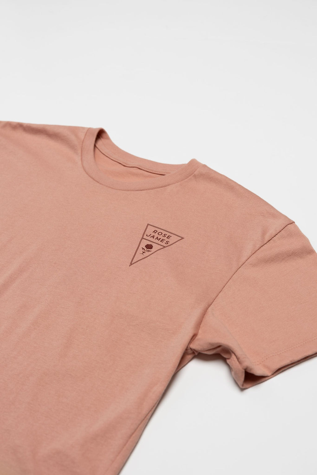 Pink t-shirt with a small logo on a white background