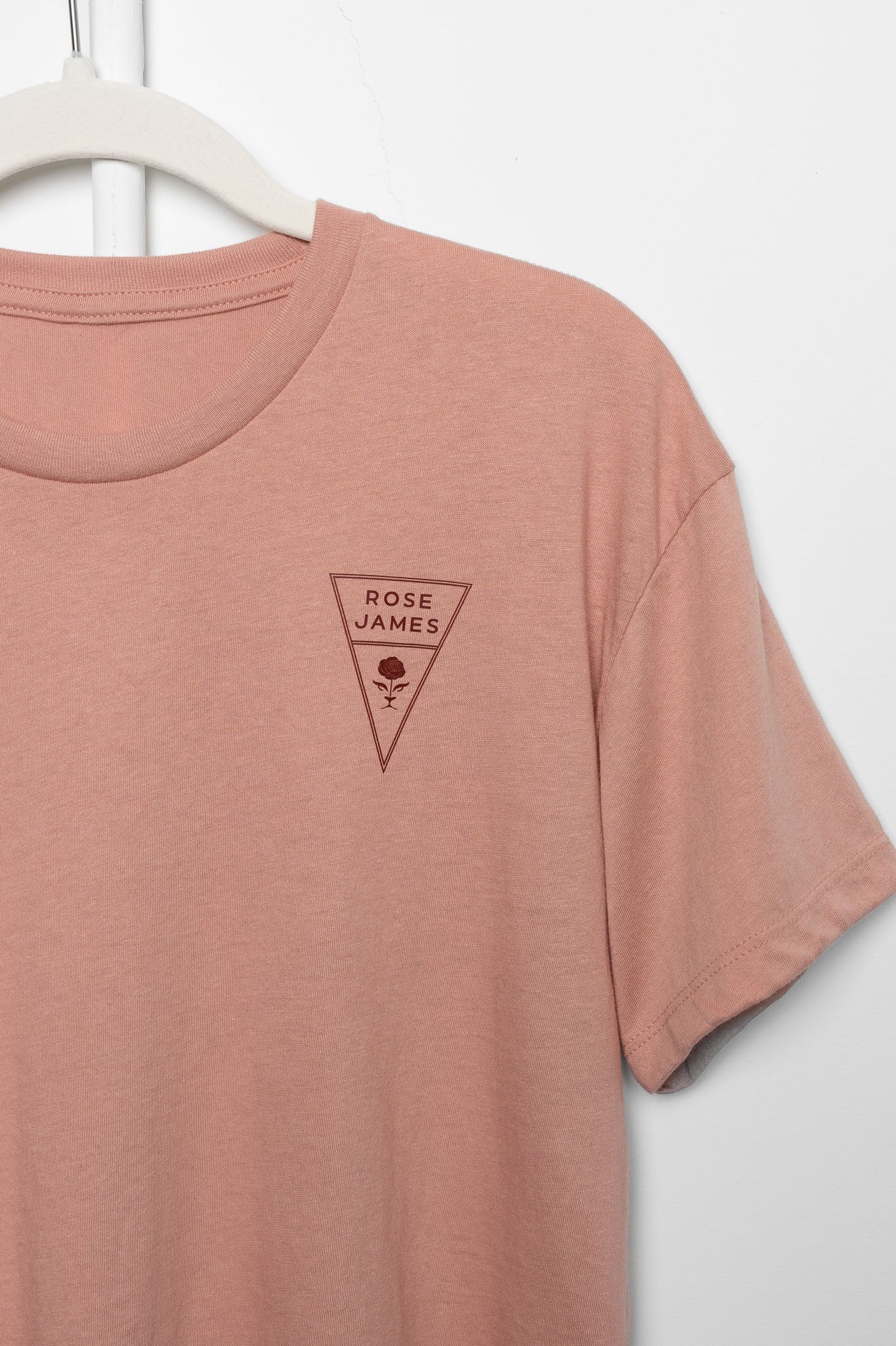 Mauve t-shirt with a triangle logo on a white background