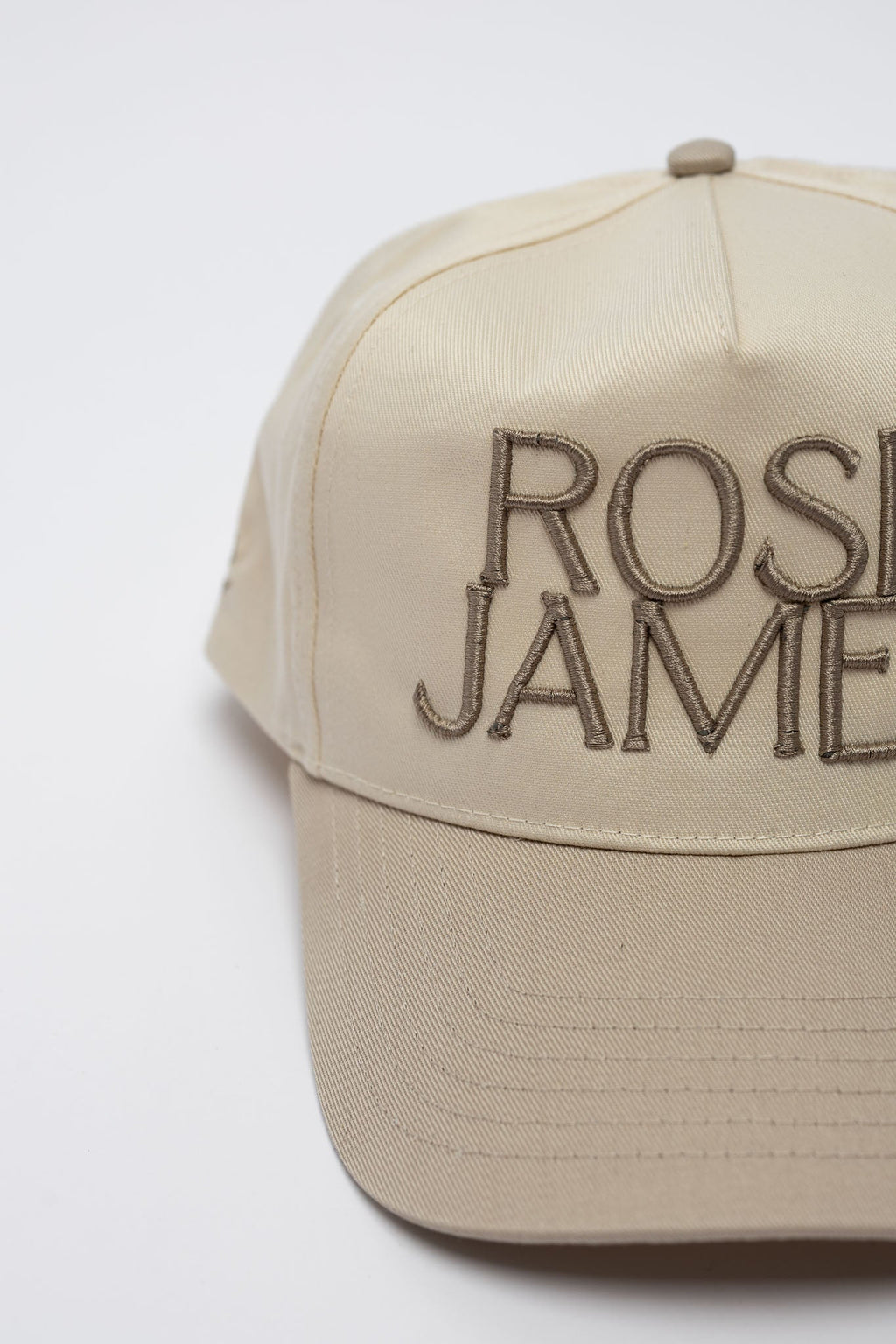Beige cap with 'ROSIE JAMIE' embroidery on a white background