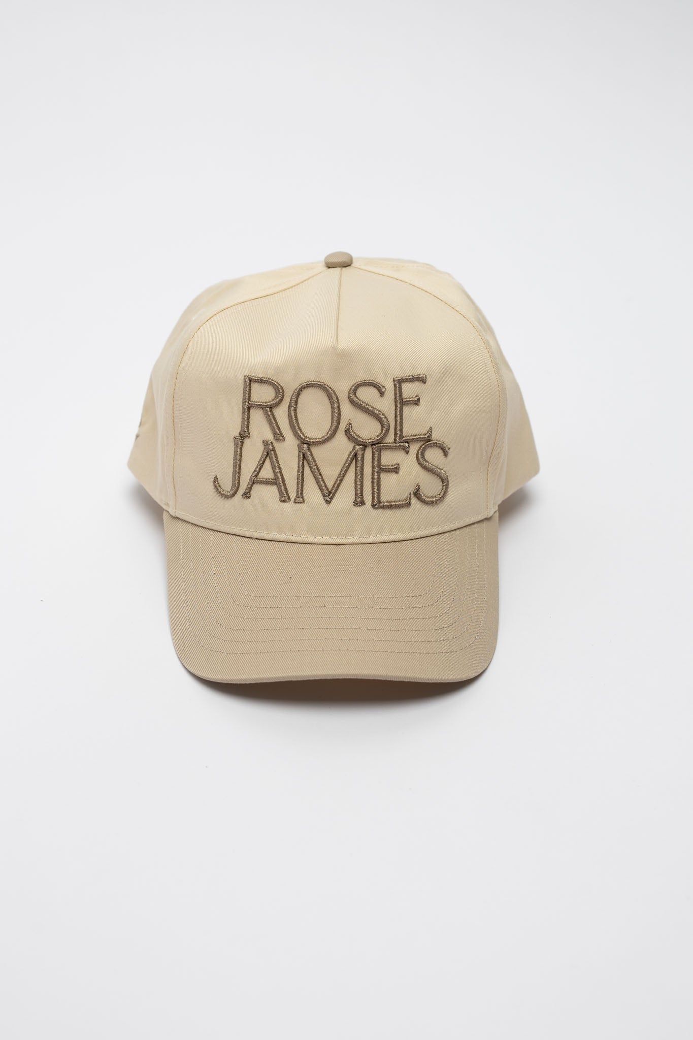 Beige cap with 'ROSE JAMES' text on a white background